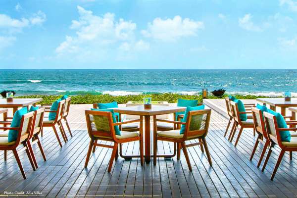 Dine outside by the ocean with seating featuring Sunbrella fabrics.