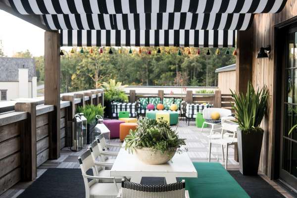 A deck with a black and white striped awning made with Sunbrella fabric.