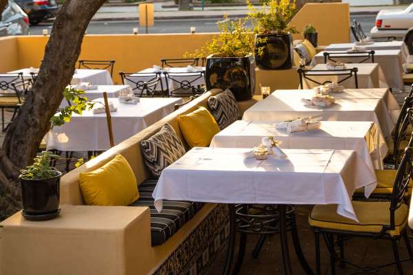 Restaurant outdoor patio seating with yellow fabric upholstery.