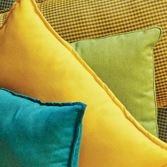 Pillows in bright yellow, green, and teal Sunbrella fabrics.