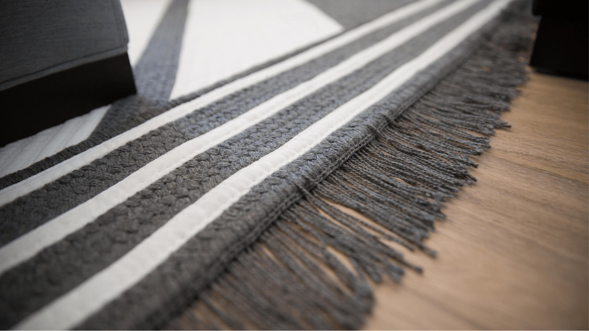 Una alfombra Sunbrella gris y blanco a rayas