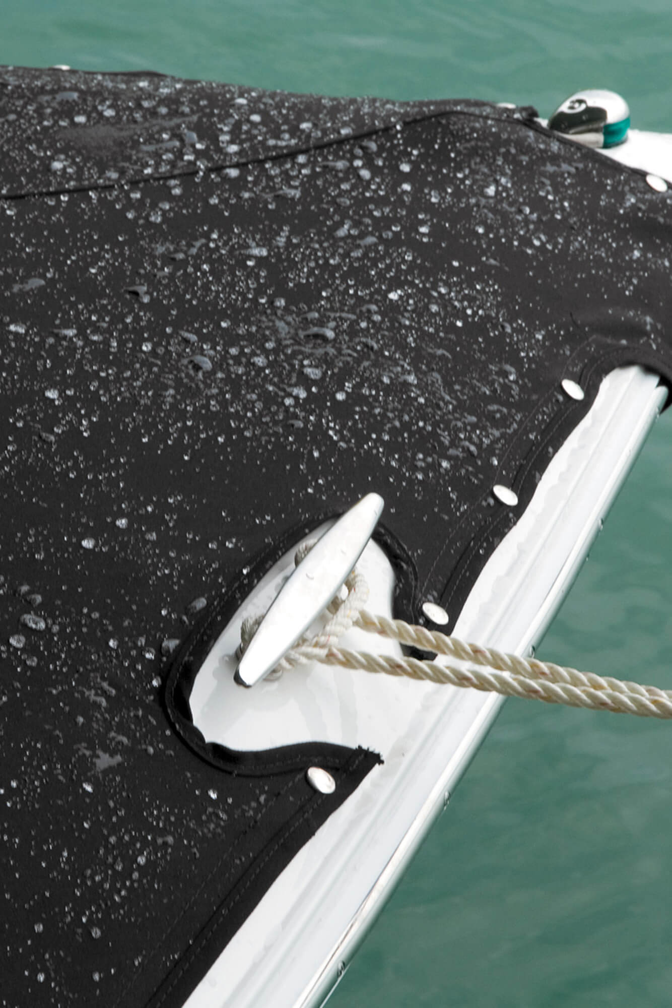 Proa de um barco motorizado, com cobertura feita em tecido preto Sunbrella