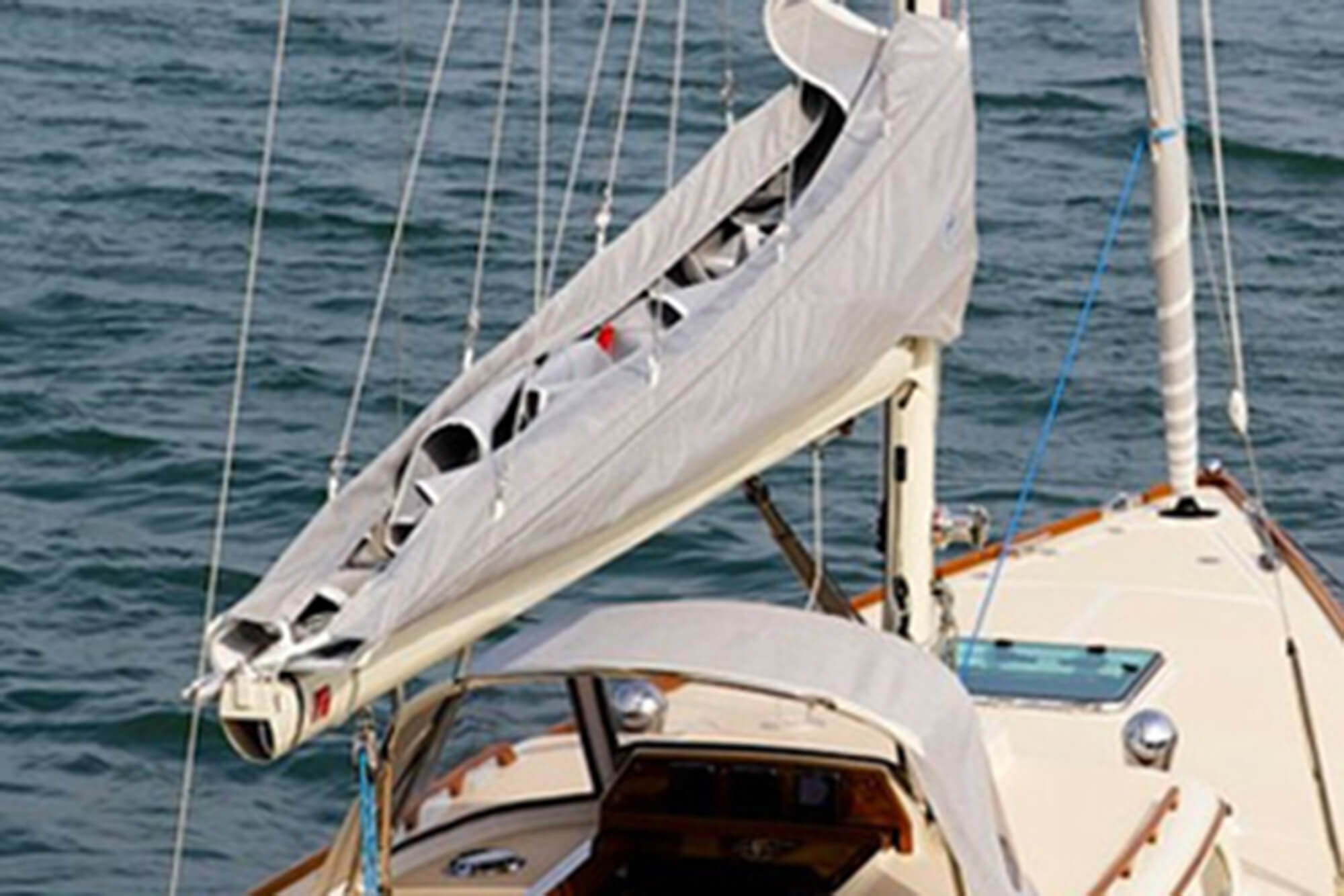 Cubierta para vela gris con tela Sunbrella protegiendo las velas de un velero