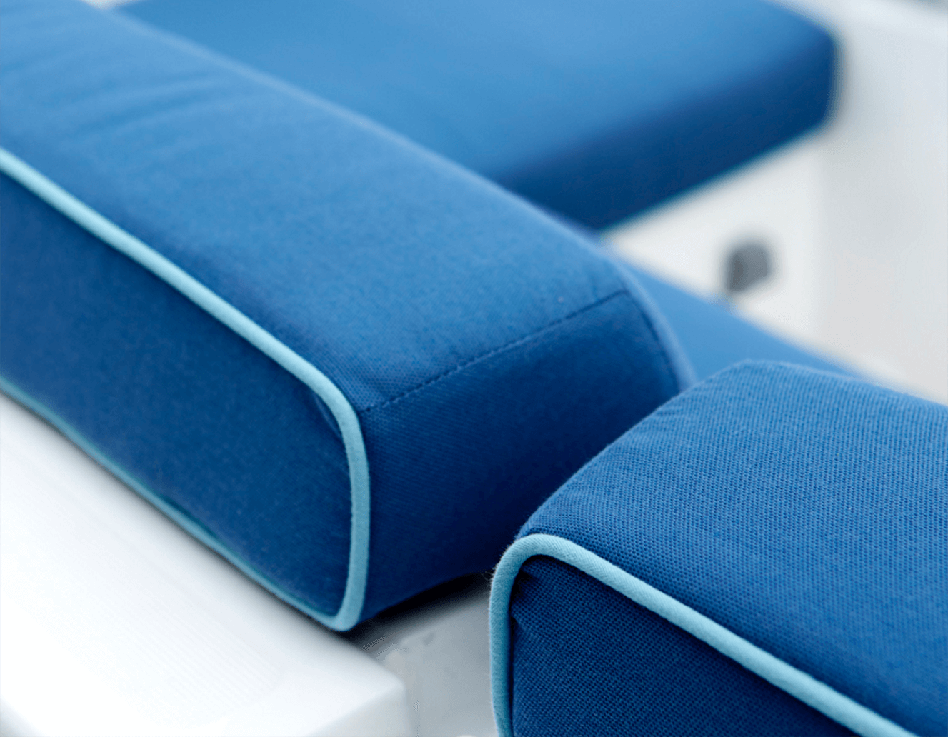 Particolare di cuscini blu con bordatura azzurra sui cuscini dei sedili di una barca