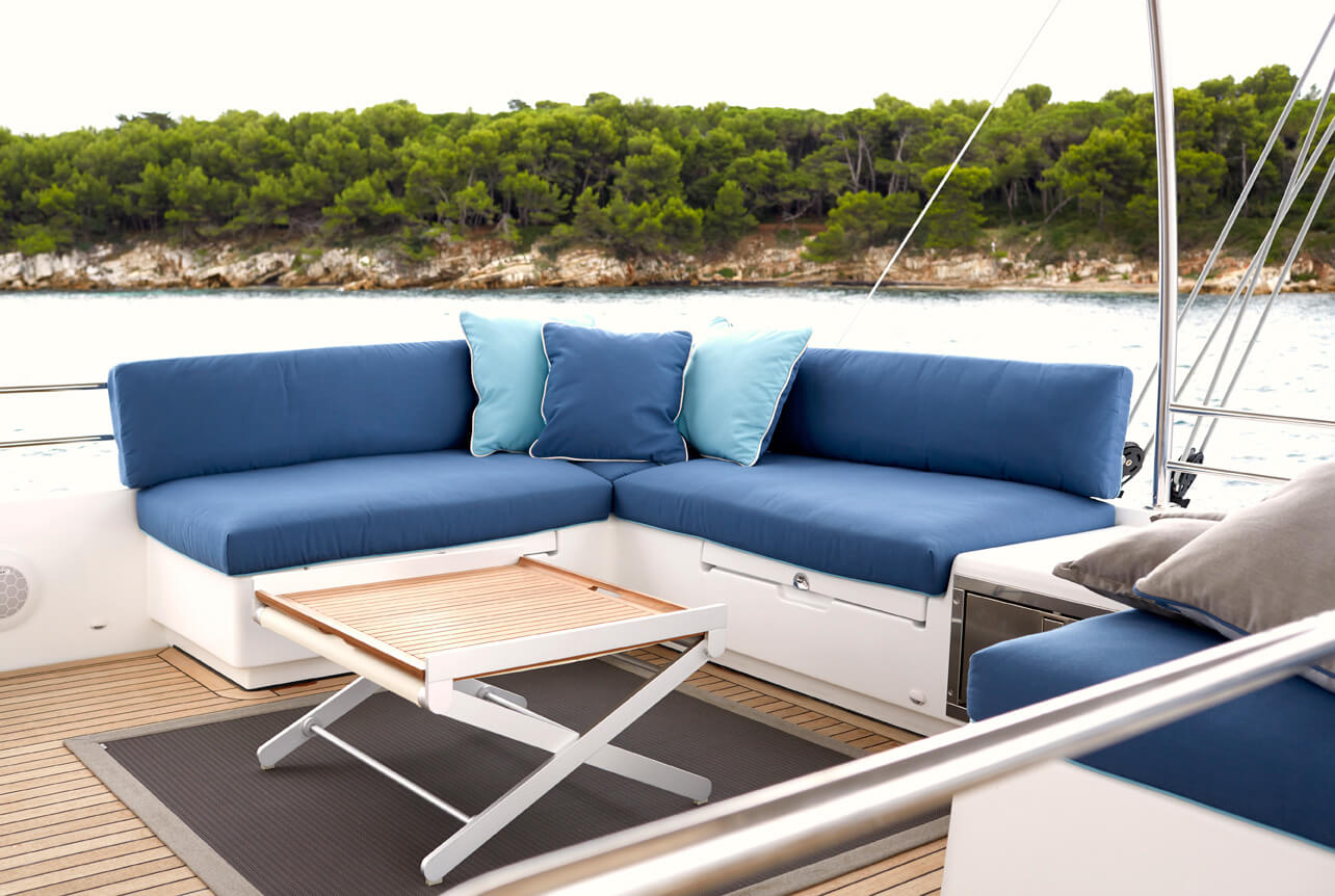 Zonas para sentarse en el exterior de un catamarán con cojines cubiertos con telas Sunbrella de color azul