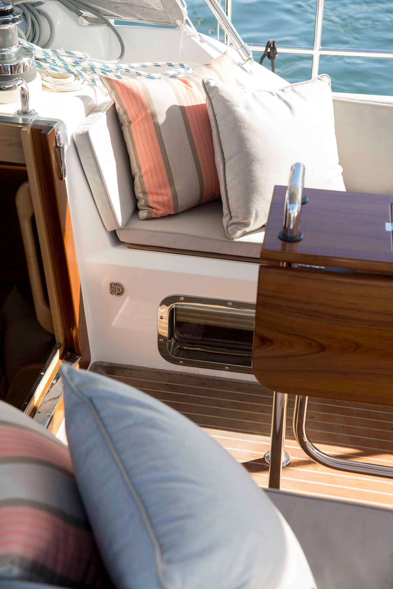 Cojines a rayas beige y rosa de tela Sunbrella sobre cojines de asiento en la cubierta de un bote