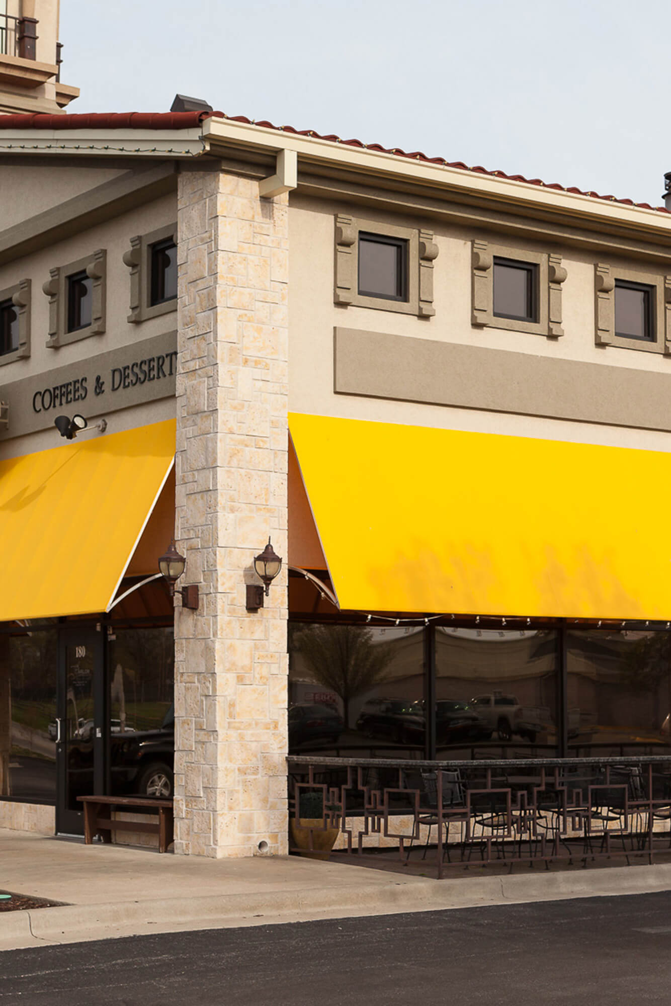 Yellow fixed frame awning made with Sunbrella Clarity fabric on a storefront