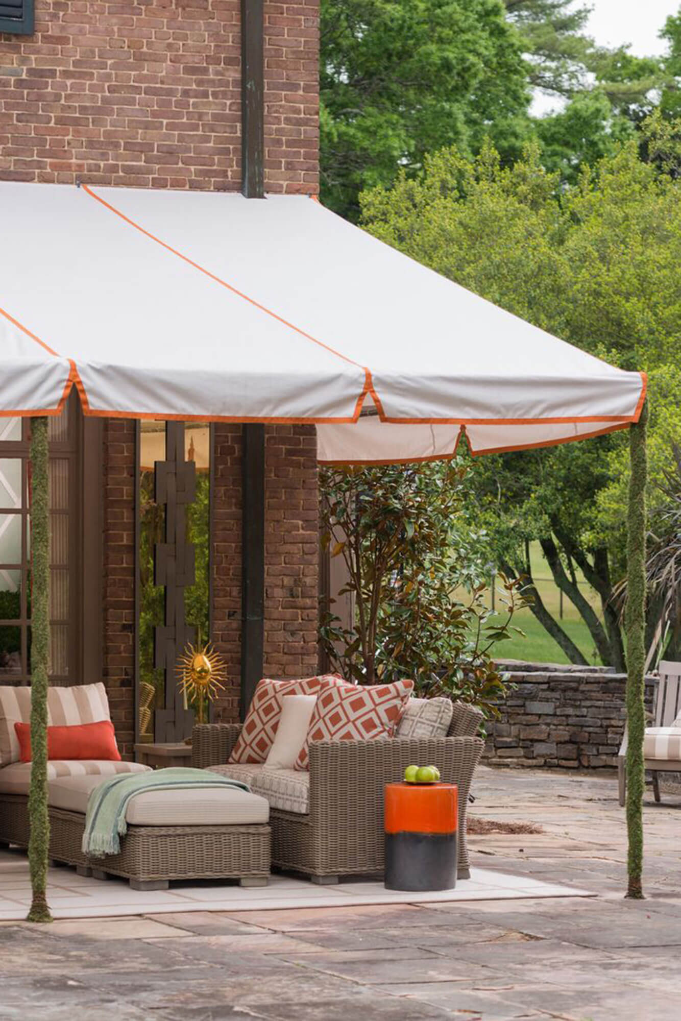 Patio couvert d’un store à cadre fixe avec un tissu Sunbrella blanc et détail orange