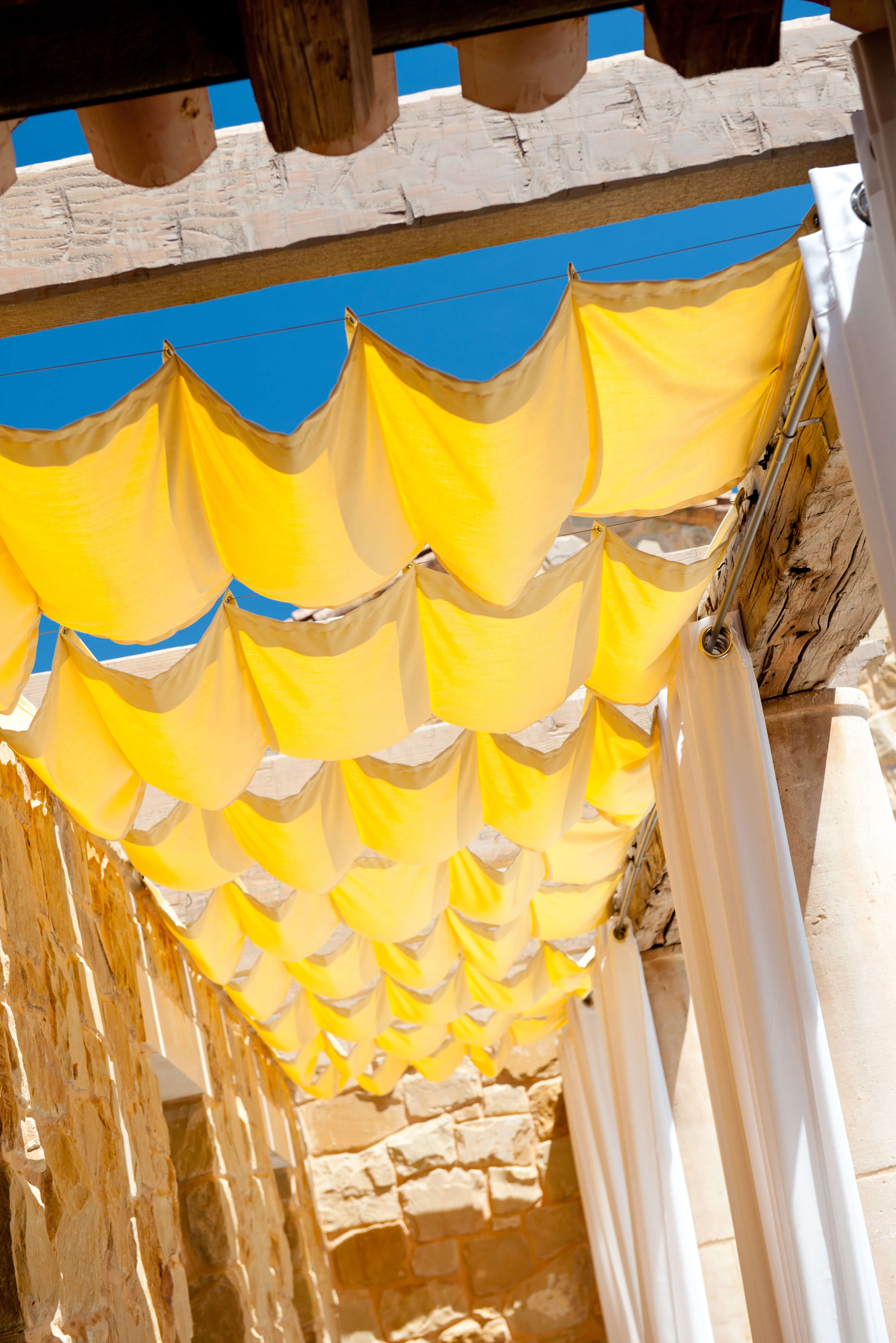 Loggia en buitendraperie gefabriceerd met gebruik van Sunbrella-stoffen beschutten een terras