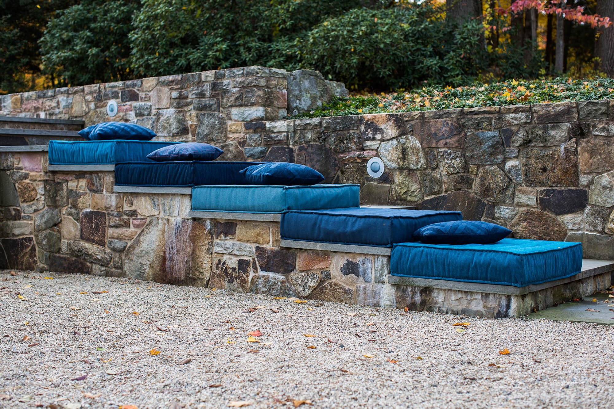 Almofadas de chão azuis feitas com tecidos Sunbrella empilhadas nos degraus ao ar livre